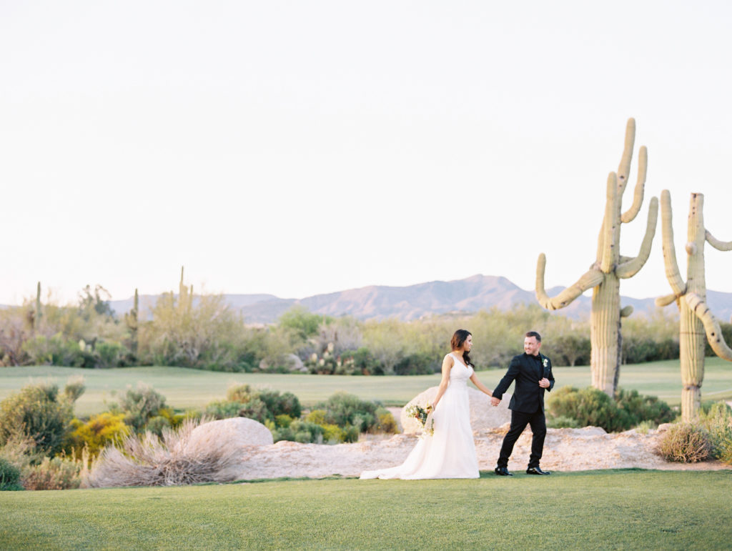 Boulders Resort wedding photo with bride and groom posing in front of a cactus